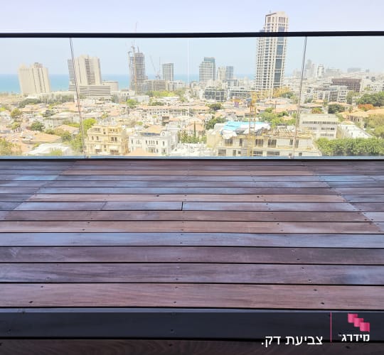 רצפת עץ במרפסת עם מעקה זכוכית